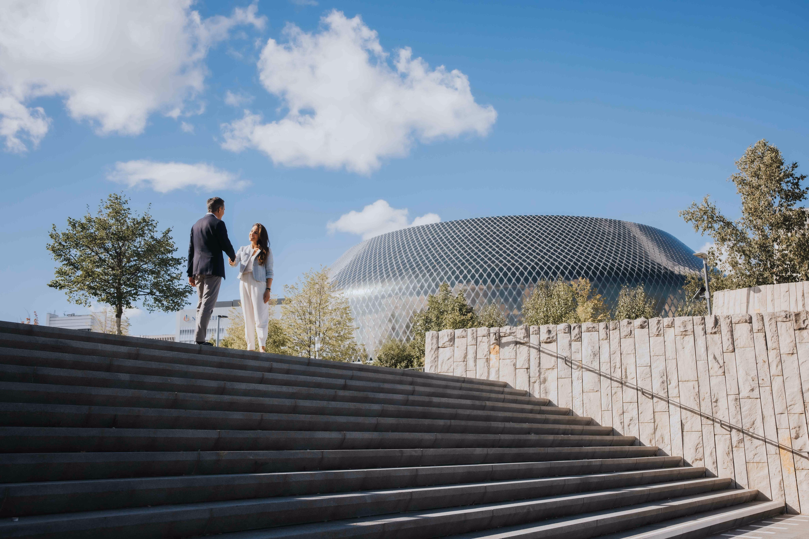 Two professionals shaking hands outside a modern building