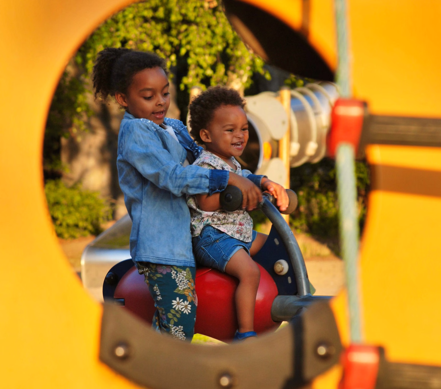 Two children playing on equipment at a park