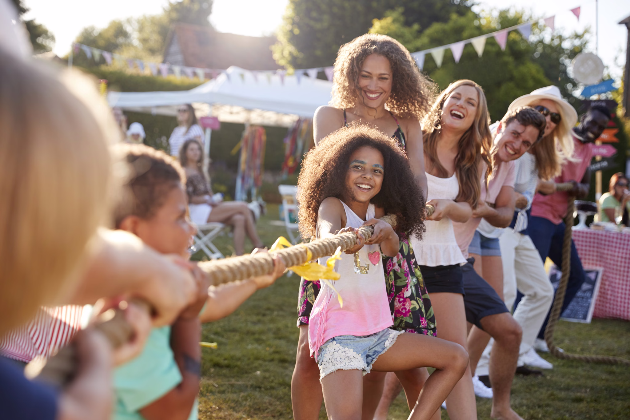 Families playing tug of war at a community fair
