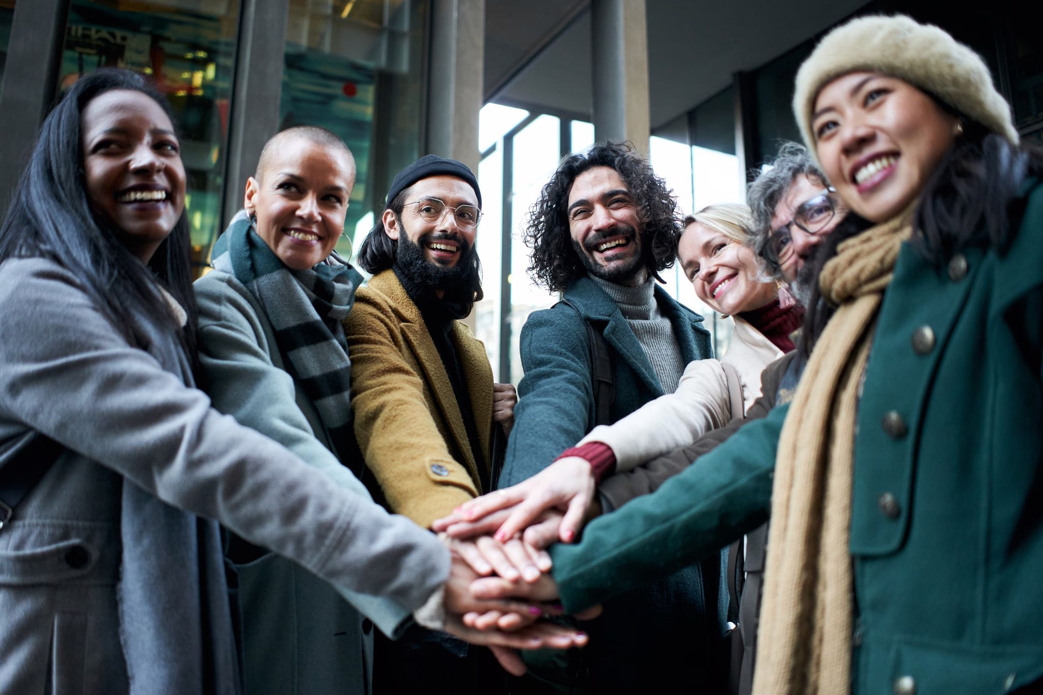 Friends stacking their hands together on a city street