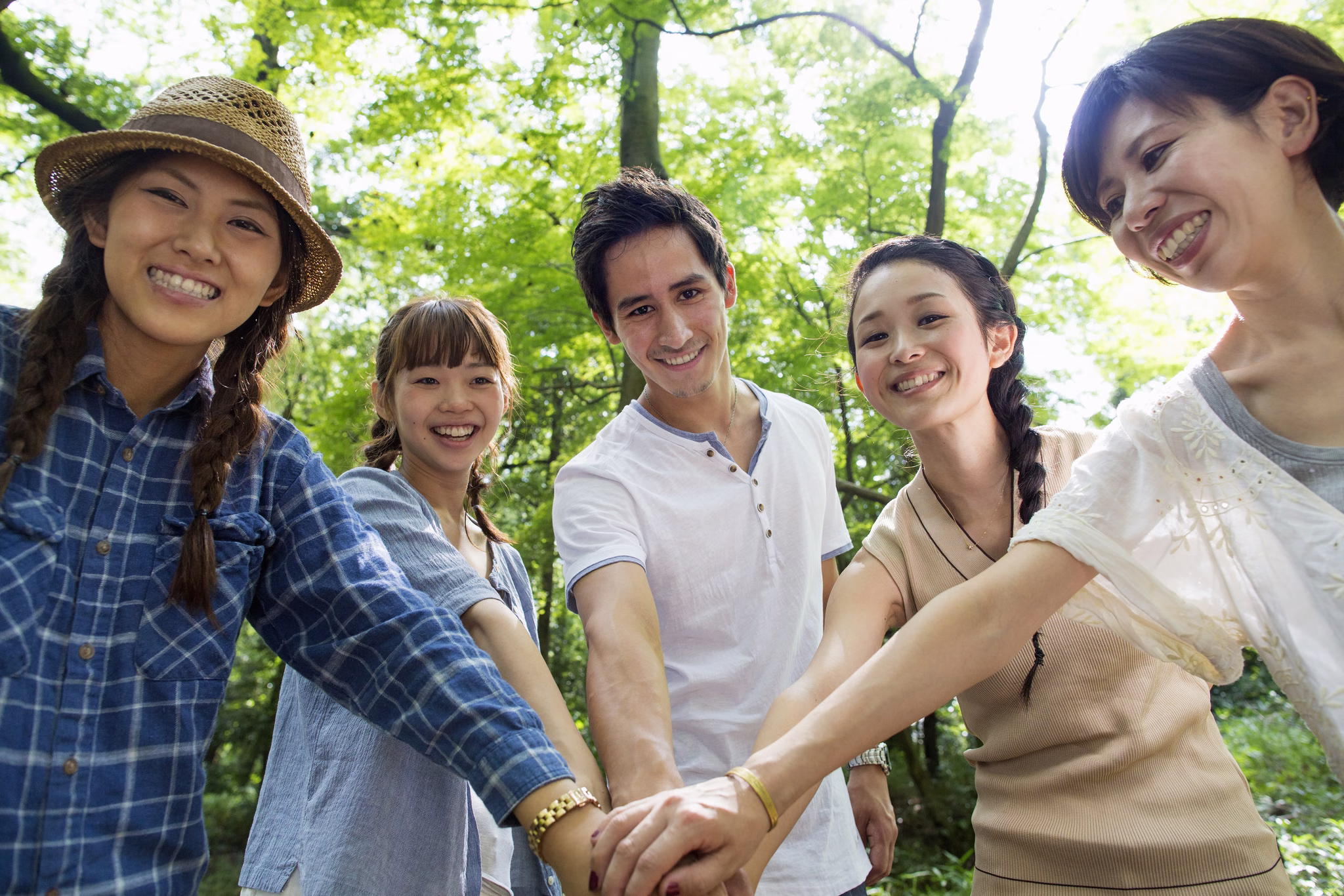 A group of friends stacking their hands together outdoors