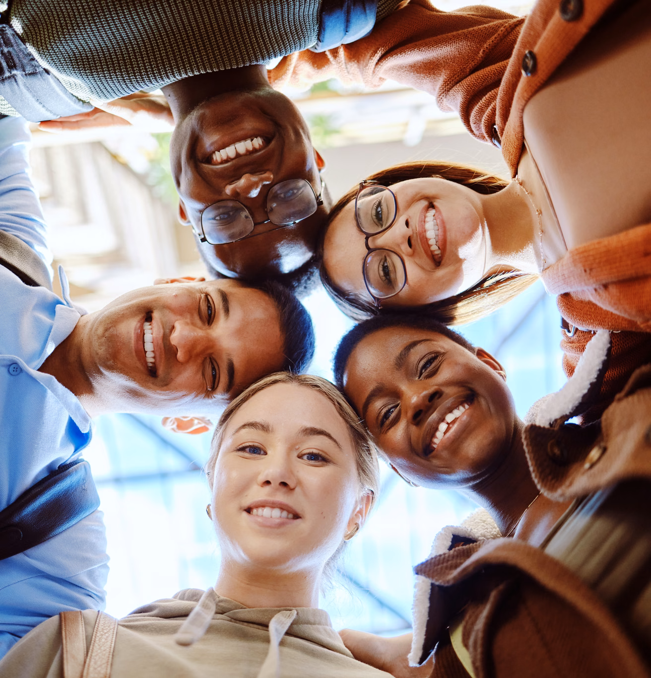 A group of young adults huddled together, looking up at the camera